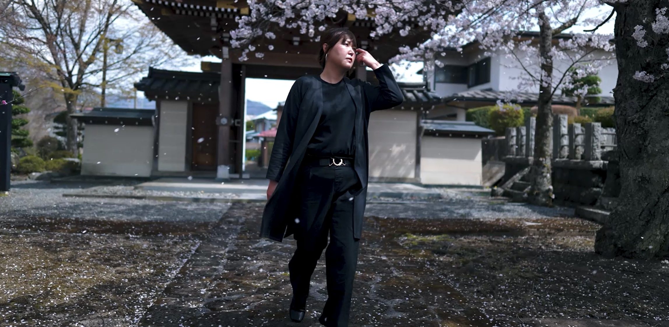 桜の花びらが舞う寺院で撮影されたポートレート